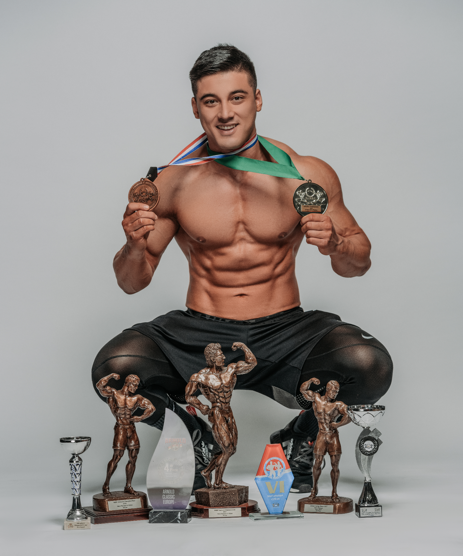Coach M.M.X with competition trophies and medals
