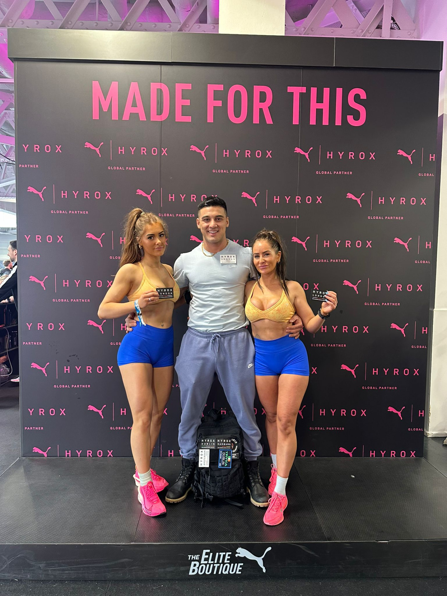 Coach M.M.X with two clients at the HYROX London 'Made for this' wall